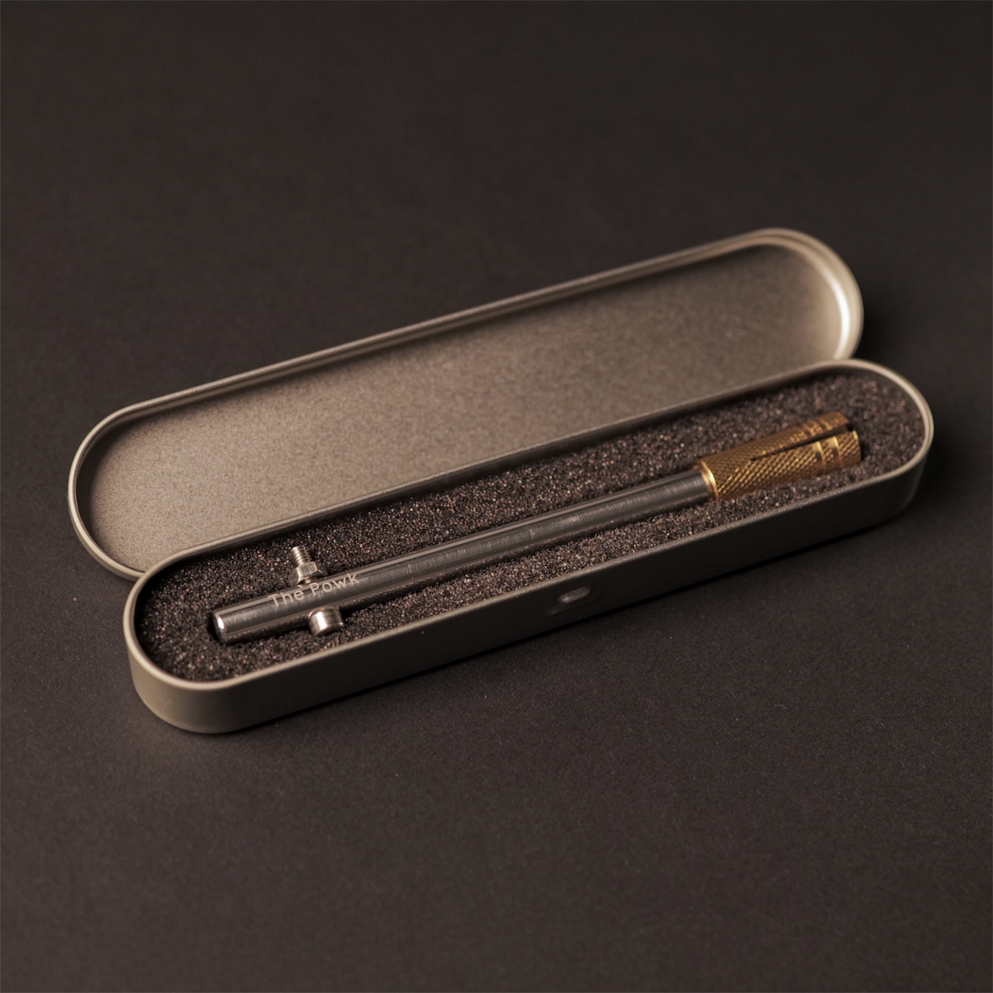 A aluminium Handpoke tattoo tool called the Powk in a protective, free, tin case, it’s a metal tattoo tool for making artwork of the skin 